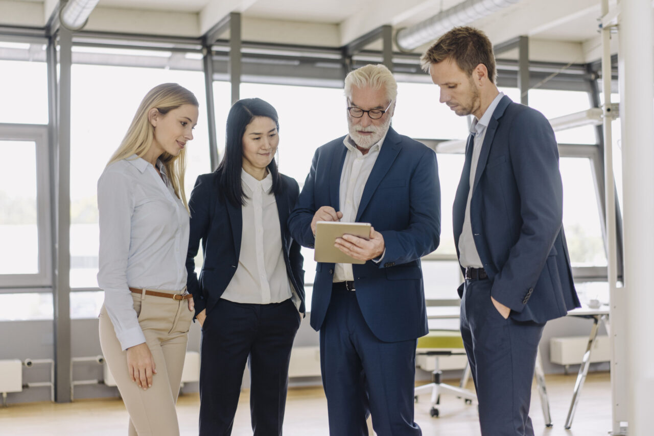 Business people with tablet having a meeting in office