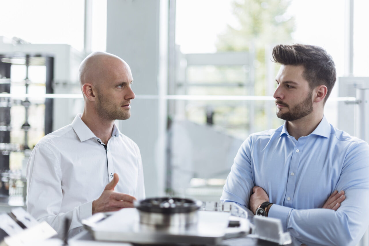 Two men discussing product in company