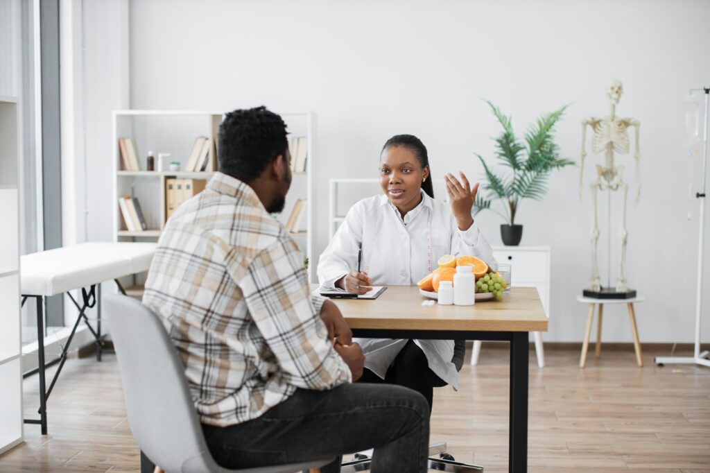 Expert in nutrition talking to man in consulting room