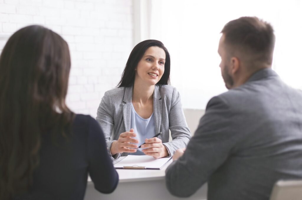 Professional woman talking to young couple at personal meeting