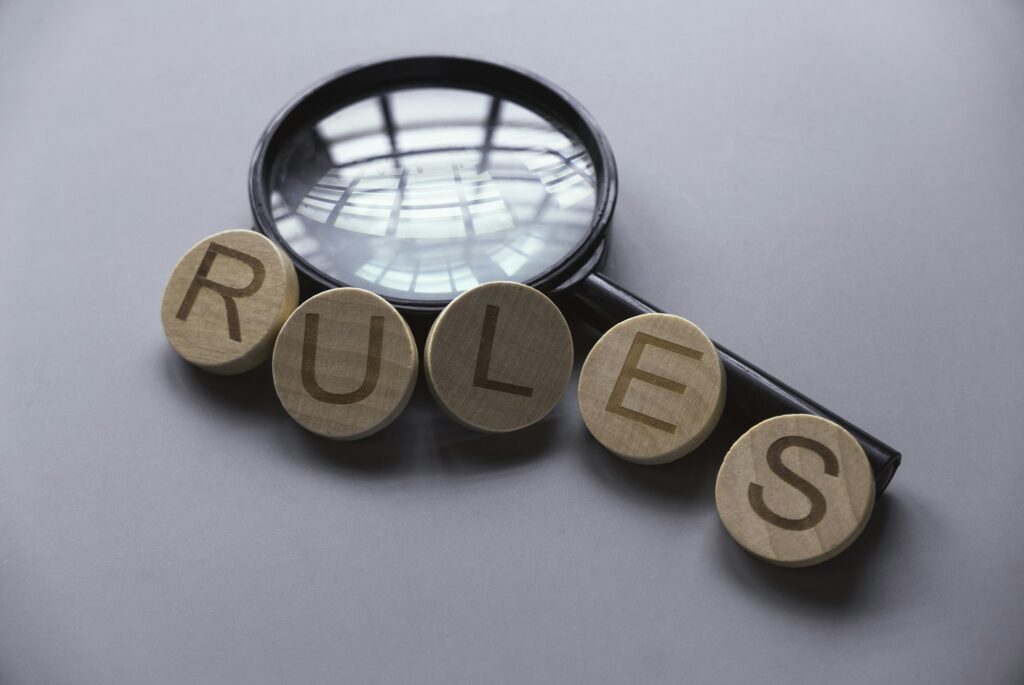 Wooden alphabet of word rules over a magnifying glass.