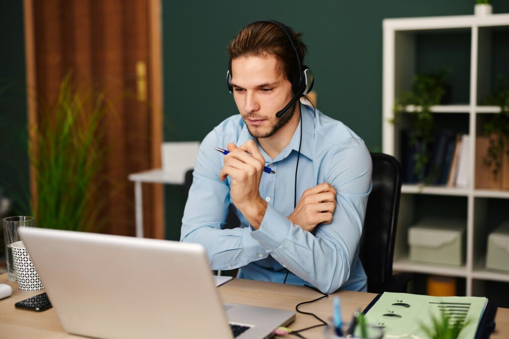 Young man working as customer support in the office